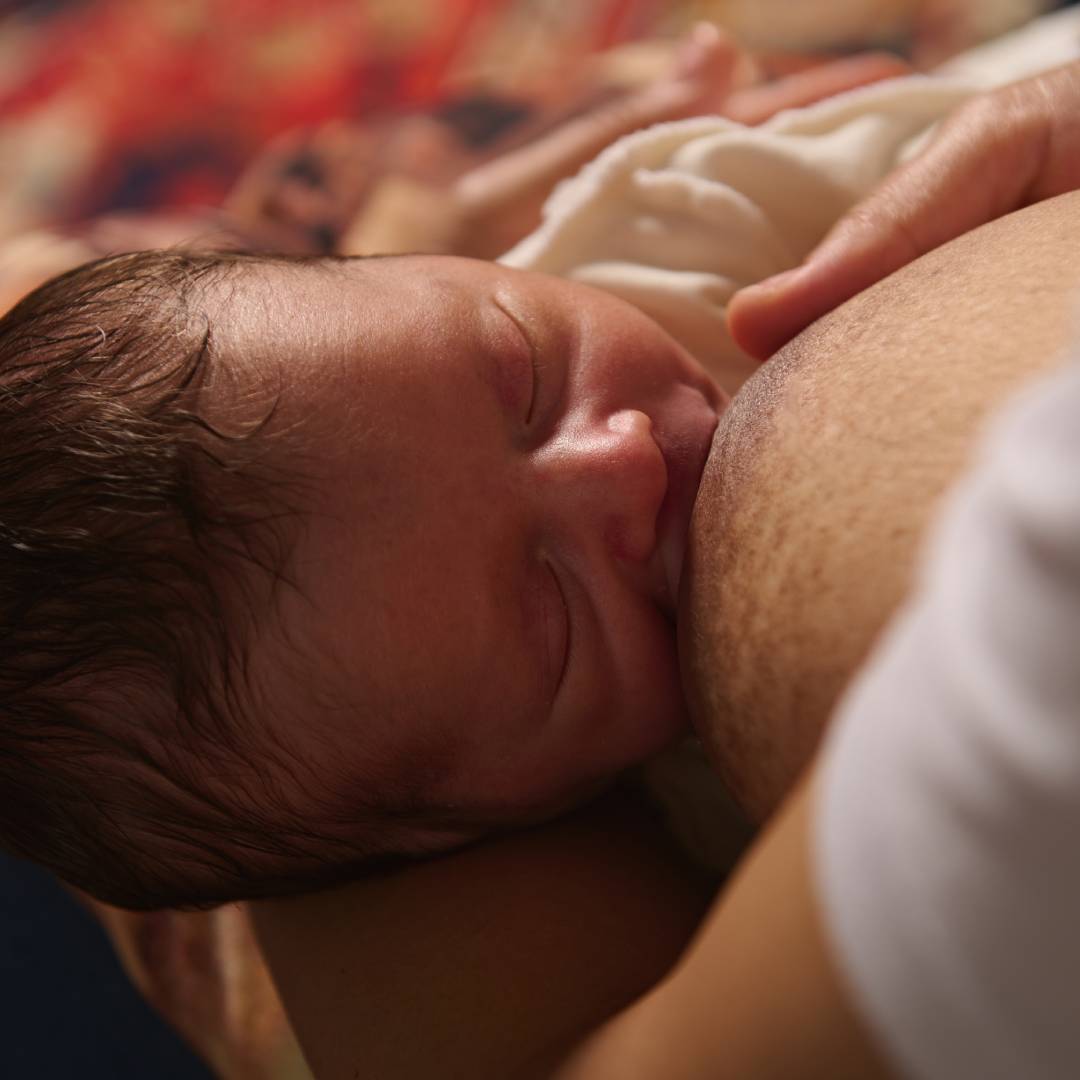 Newborn baby being breastfed